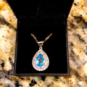 Aquamarine colored stone surrounded by cluster of clear stones Necklace